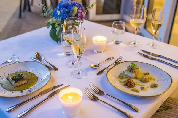 Abendessen-Tisch-Setup im The Views Oasis Hotel mit zwei Tellern, Gläsern und Kerzen