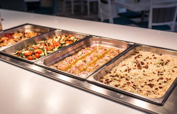 Buffet-Tisch im Views Oasis Hotel mit verschiedenen Gerichten wie Salat, Fleisch und Reis.