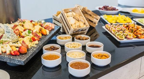 Buffettisch mit Käse, Obst und Getränken im The Views Oasis Hotel.