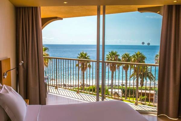 Blick aus dem Zimmer des Views Oasis Hotels auf das Meer und Palmen.
