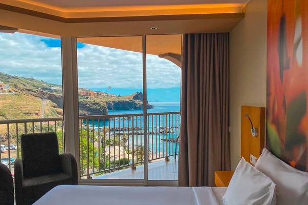 Blick aus dem Zimmer des Views Oasis Hotels auf das Meer und eine Terrasse.
