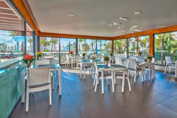 Ansicht des Restaurants des Views Oasis Hotels mit großen Fenstern und Meeresblick.