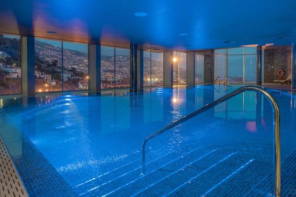 Innenpool des The Views Baia Hotels mit blauen Lichtern und Stadtblick