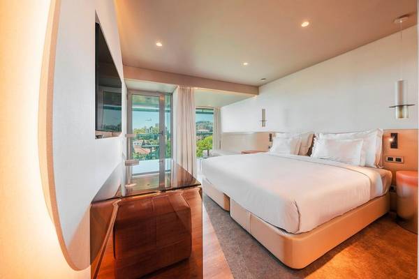 Schlafzimmer im Views Baia Hotel mit großem Bett und Stadtblick.