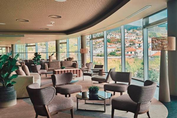 Loungebereich im Hotel The Views Baia mit großen Fenstern und Blick auf die Stadt.