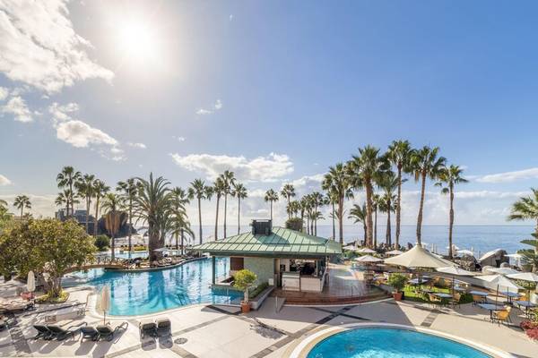 Außenpool des Royal Savoy Hotels mit Loungebereich und Blick aufs Meer.