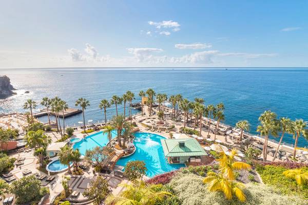 Luftaufnahme des Royal Savoy Hotels mit Swimmingpool und Blick auf das Meer.