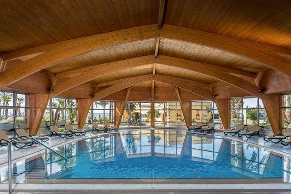 Innenpool des Royal Savoy Hotels mit blauem Wasser und hölzernen Strukturen