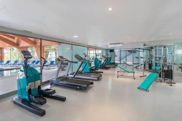 Fitnessraum im Royal Savoy Hotel mit moderner Trainingsgeräten und blauen Liegebänken.