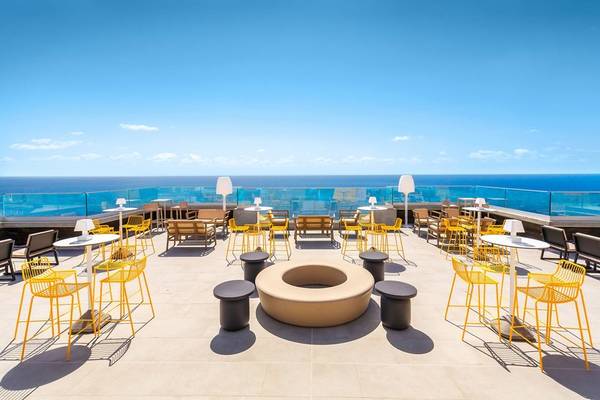 Allegro Madeira Hotel Dachterrasse mit Meerblick, gelben Stühlen und Tischen.