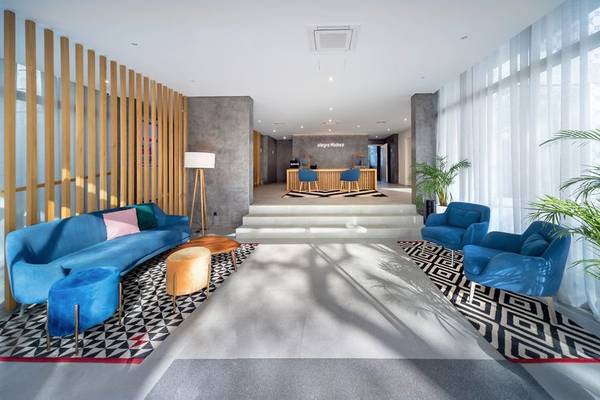 Allegro Madeira Hotel Lobby mit blauen Möbeln, Holzelementen und Pflanzen.