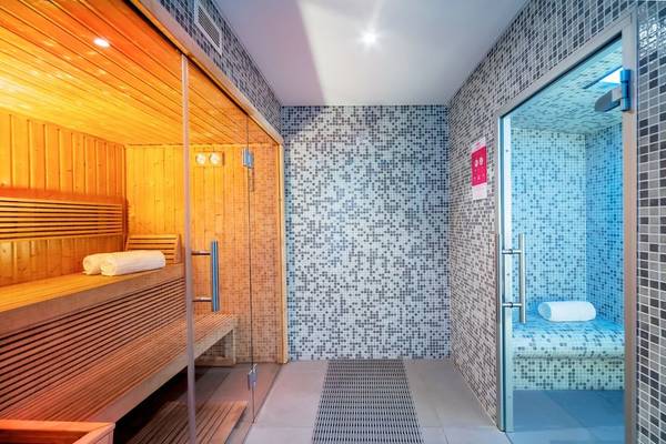 Sauna im Allegro Madeira Hotel mit Holzbank und blauen Fliesen.