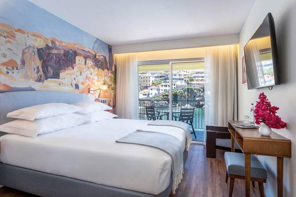 Hotelzimmer im Pestana Churchill Bay mit Meerblick, großem Bett, Balkon und Stadtsicht.