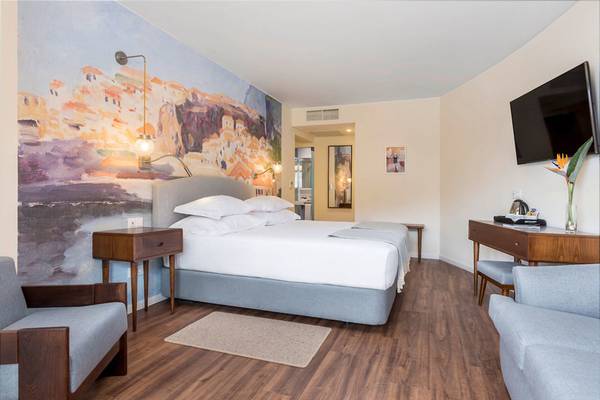 Ein modernes Hotelzimmer im Pestana Churchill Bay mit einem großen Bett und einem Fernseher.