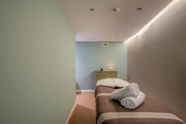 Massageraum im Pestana Churchill Bay Hotel mit grünen Wänden und Holzboden.