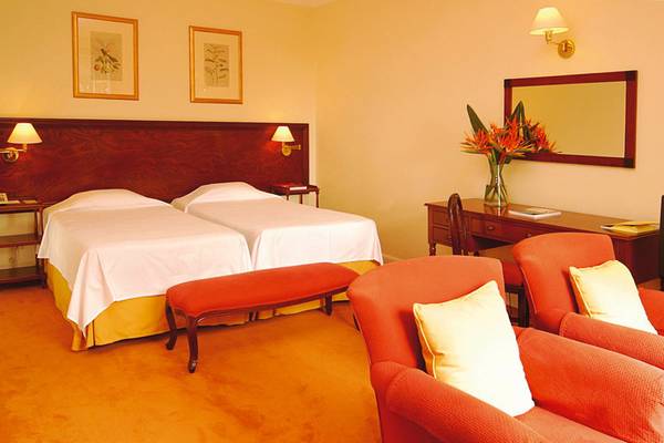 Doppelzimmer im Hotel Quinta da Bela Vista mit zwei Betten, Nachttischen, Lampen und Dekor