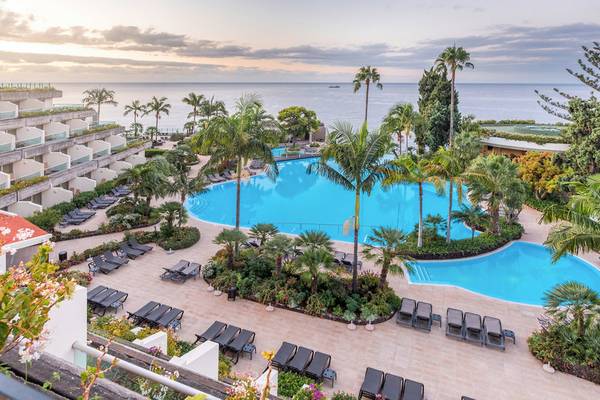 Luftaufnahme des Pestana Carlton Madeira Resorts mit Swimmingpool und Meerblick.