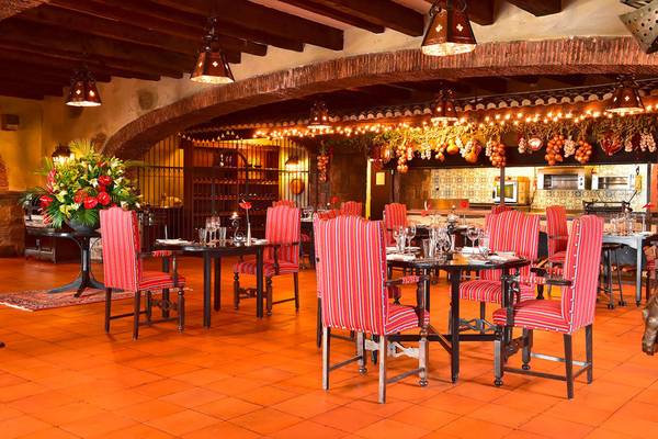 Innenansicht des Restaurants im Pestana Carlton Madeira Hotel mit roten Stühlen und orangefarbenen Böden.