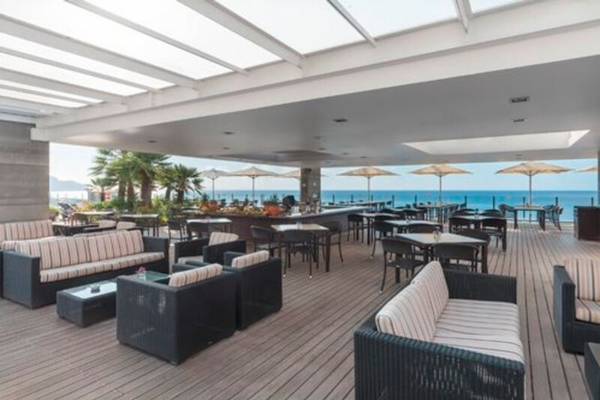 Terrasse des Pestana Carlton Madeira Hotels mit Blick auf das Meer und Palmen
