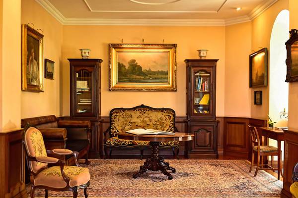 Inneneinrichtung des Pestana Miramar Garden & Ocean Resort mit Sofa, Tisch, Stühlen und Gemälden an der Wand.