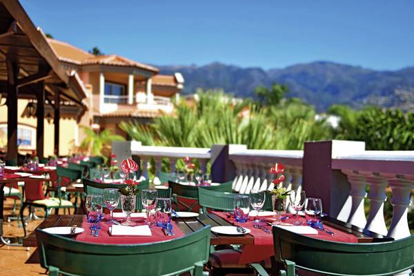 Terrasse des Pestana Miramar Garden & Ocean Resort mit Blick auf das Meer und die Berge.