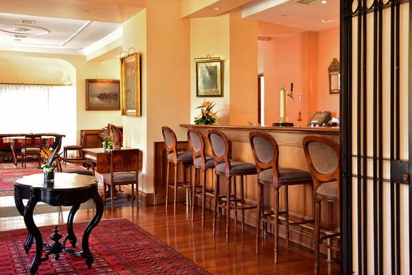 Barbereich des Pestana Miramar Garden & Ocean Resorts mit Holzbarstühlen und Tisch.