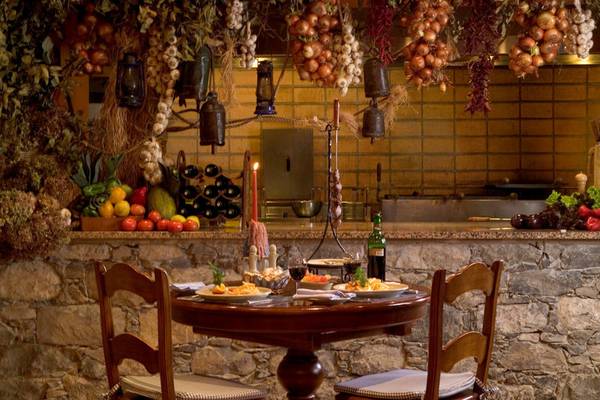 Innenbereich des Pestana Miramar Garden & Ocean Resorts mit gedecktem Tisch und Steinmauer.