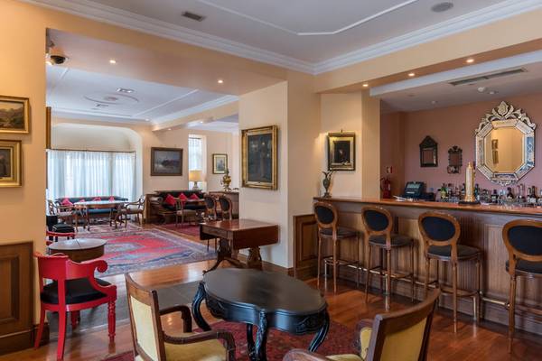 Innenansicht der Bar im Pestana Miramar Garden & Ocean Resort mit Barhockern, Tischen und Dekor.
