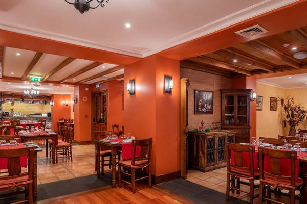 Innenansicht des Pestana Miramar Garden & Ocean Resort Restaurants mit orangefarbenen Wänden und Holzmöbeln.