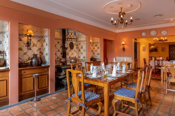 Speisesaal im Pestana Miramar Garden & Ocean Resort mit gedecktem Tisch, Holzmöbeln und traditioneller Wanddekoration.