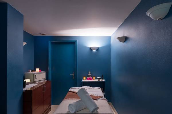 Massageraum im Pestana Miramar Garden & Ocean Resort mit blauen Wänden und einem Behandlungsbett.