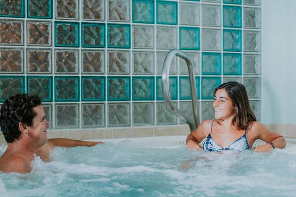 Mann und Frau entspannen sich in einer Whirlpool-Badewanne im Pestana Miramar Garden & Ocean Resort.