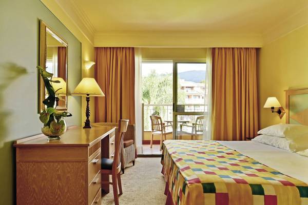 Hotelzimmer im Pestana Miramar Garden & Ocean Resort mit Balkon, Bett, Schreibtisch und Möbeln.
