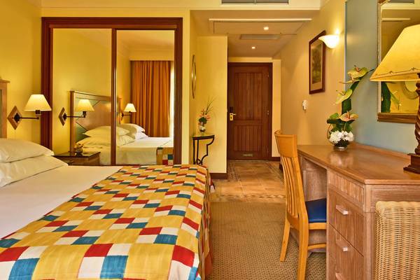 Hotelzimmer im Pestana Miramar Garden & Ocean Resort mit Bett, Schreibtisch und Badezimmerspiegel.