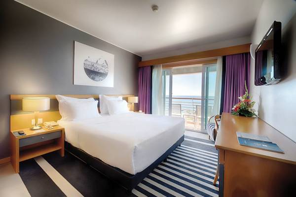 Zimmer im Pestana Casino Park Hotel mit Bett und Balkon.
