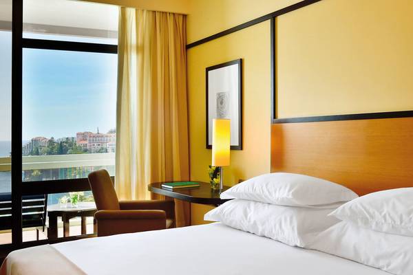 Hotelzimmer im Pestana Casino Park mit Ausblick auf die Stadt und das Meer.