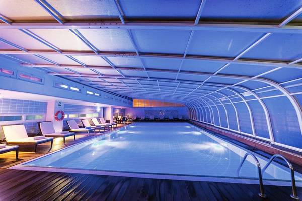 Innenpool des Pestana Casino Park Hotels mit blauer Beleuchtung und Lounge-Stuhlreihen.
