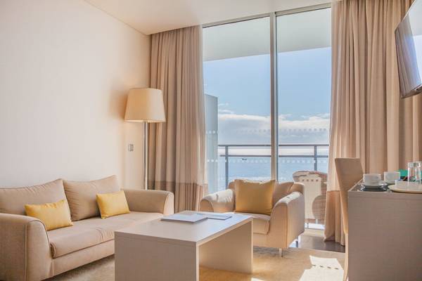 Wohnzimmer im VidaMar Resort Hotel Madeira mit Blick auf das Meer und die Wolken