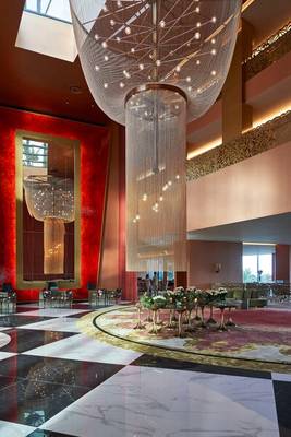 Lobby des Savoy Palace Hotels mit einer großen, leuchtenden Kronleuchter im Mittelpunkt.