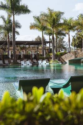 Außenpool des Savoy Palace Hotels mit Loungesesseln und Palmen