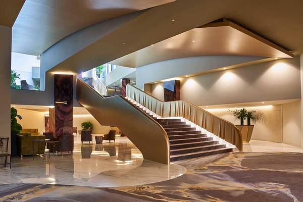 Empfangsbereich des Savoy Palace Hotels mit Marmorboden und gewendelter Treppe.