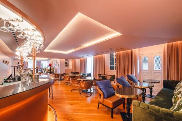 Innenansicht der Lounge im Savoy Palace Hotel mit Bar, Tischen, Stühlen und dekorativen Elementen.