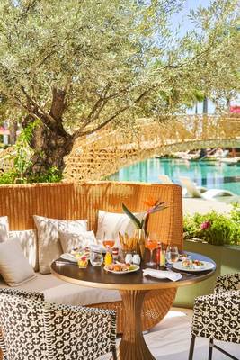 Außensitzbereich des Savoy Palace Hotels mit Frühstückstisch und Blick auf den Pool.