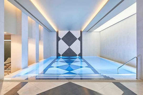 Innenpool des Savoy Palace Hotels mit blauen Wasser und geometrischem Bodendesign.