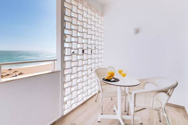 Balkon des Sol e Mar Hotels mit Meerblick, zwei Stühle und ein Tisch mit Orangensäften
