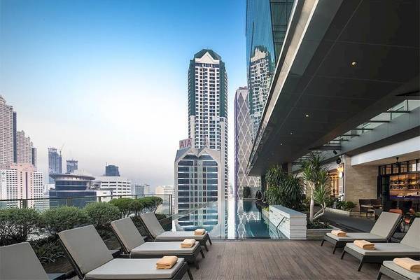 Dachterrasse des Eastin Grand Hotel Sathorn mit Loungeliegen und Blick auf die Stadt