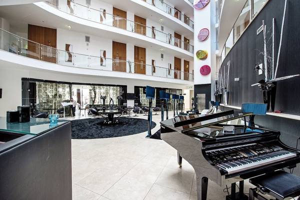 Lobby des Aqua Pedra dos Bicos Hotels mit Klavier und Sitzbereich.