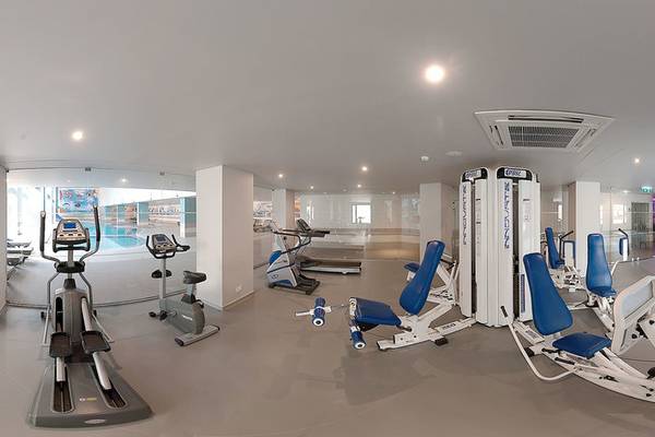 Fitnesscenter im Vila Galé Cerro Alagoa Hotel mit verschiedenen Trainingsgeräten und Blick auf den Pool.