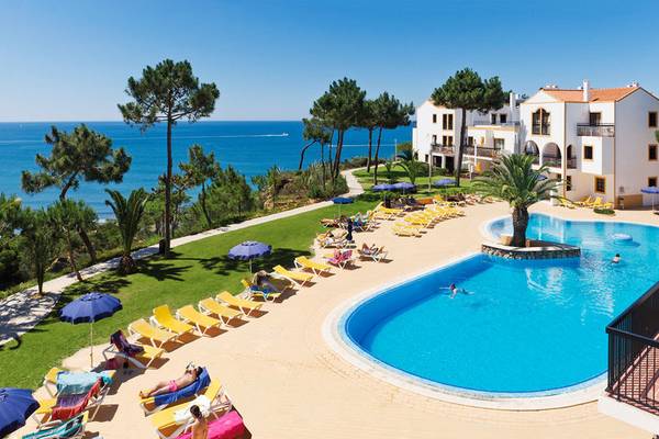Alfagar Village Hotel Außenbereich mit Pool und Sonnenliegen am Meer