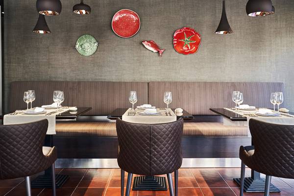 Innenansicht des Restaurants im Falesia Hotel in Algarve mit Tisch, Stühlen und dekorativen Wandelementen.